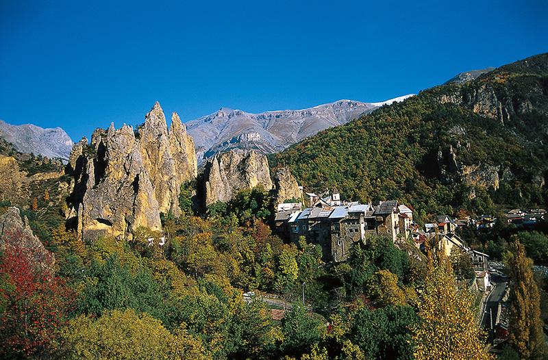  Le village de Péone en couleurs automnales, dominé par ses aiguilles rocheuses dolomitiques très caractéristiques nommées les "Demoiselles"