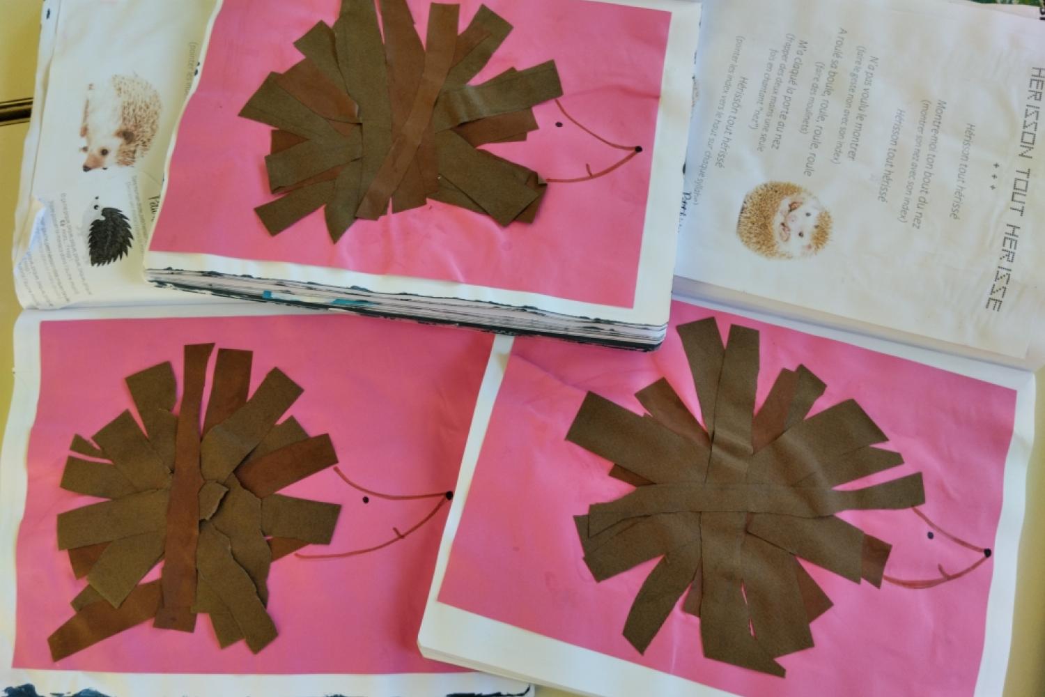 Trois dessins de hérissons sur fond rose dont les pics sont un collage de bandes marrons Deux dessins de hérisson suspendus au plafond © M.Bensa / PNM